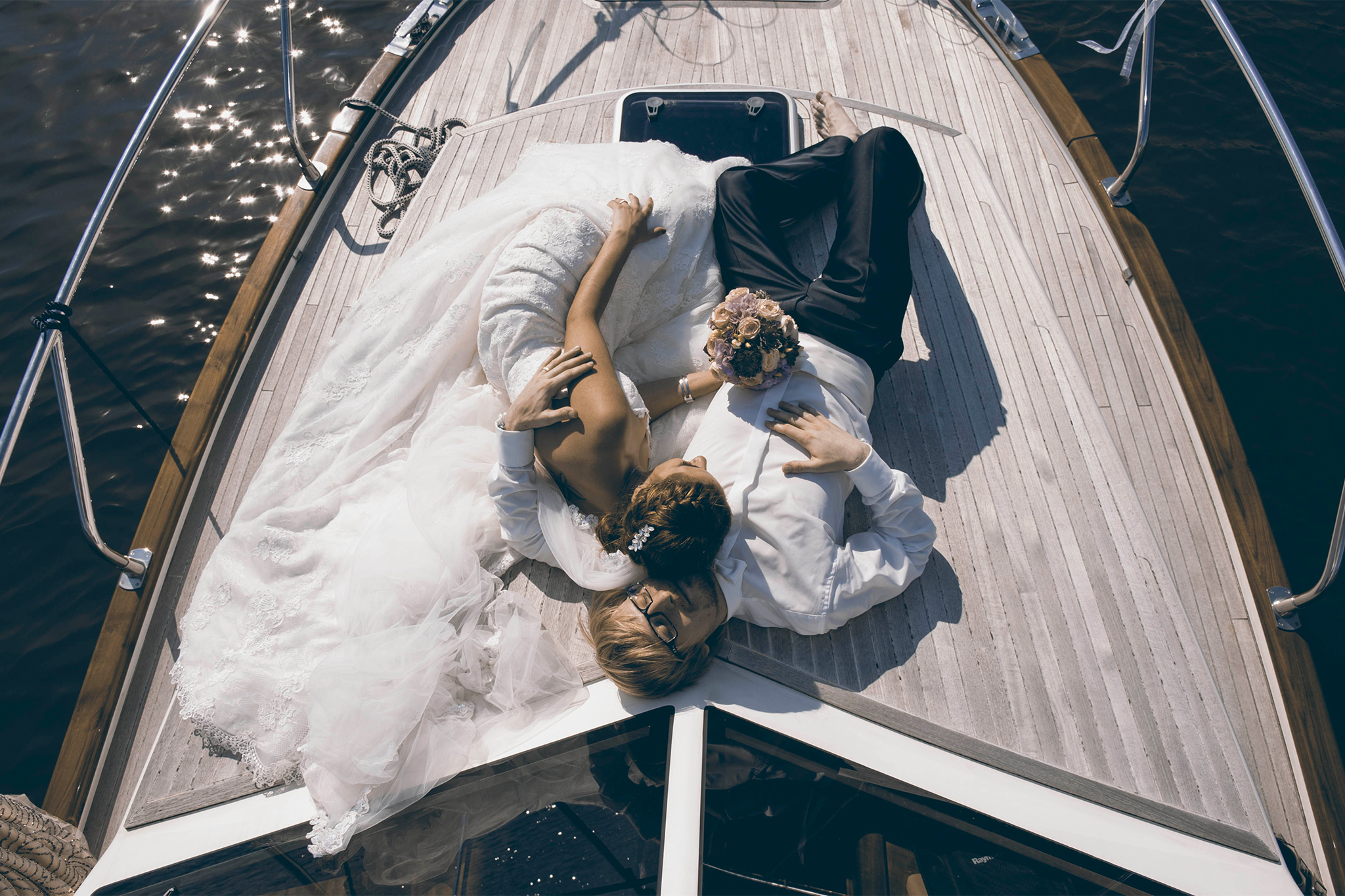 Brautpaar mit Brautstrauß genießt die Hochzeit auf dem Boot