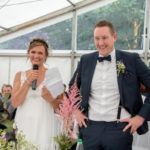 Braut und Bräutigam halten eine Rede auf ihrer Hochzeitsfeier